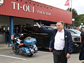 Coalition Avenir Quebec Leader François Legault waves to supporters as he leaves a popular snack bar in Saint-Raymond on Thursday.
