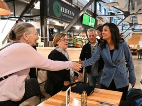 Quebec Liberal Leader Dominique Anglade, right, shakes hand with a shopper at a local farmer's market, Tuesday, Sept. 27, 2022 in Quebec City. Quebecers are going to the polls for a general election on Oct. 3rd.