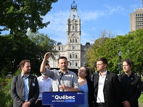 Parti Québécois Leader Paul St-Pierre Plamondon speaks at a news conference in front of the legislature, Thursday, September 8, 2022 in Quebec City, flanked by local candidates.