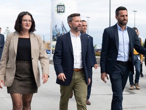 Québec solidaire co-spokesperson Gabriel Nadeau-Dubois, flanked by local candidates Karoline Boucher, left, and Olivier Bolduc, walk to a news conference, Tuesday Sept. 27, 2022 in Quebec City.