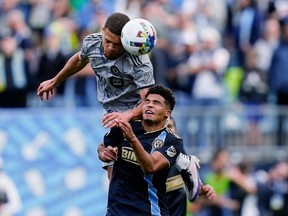 CF Montreal defender Zorhan Bassong, top, heads the ball over Philadelphia Union defender Nathan Harriel (26) during the second half of an MLS soccer match&ampnbsp;in Chester, Pa., Saturday, April 23, 2022.