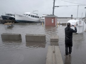 A resident takes photographs of flooding following post-tropical storm Fiona in Shediac, N.B.