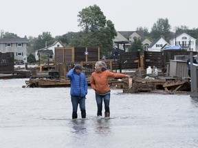 Residents stand in floodwaters in the wake of post-tropical storm Fiona, in Shediac, N.B.