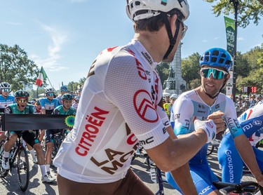 Riders exchange fist bumps before the start of the Grand Prix Cyclistes race in Montreal on Sept. 11, 2022.