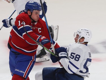 Canadiens' Nick Suzuki (14) is held back by Toronto Maple Leafs' Michael Bunting (58) during first period NHL action in Montreal on Wednesday October 12, 2022. Bunting received a penalty on the play.