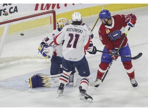 Alex Belzile of the Laval Rocket watches as a goal by teammate Rafaël Harvey-Pinard goes in past goalie Charlie Lindgren and defenceman Luke Witkowski of the Springfield Thunderbirds in Game 5 of their Calder Cup Eastern Conference AHL final at Place Bell in Laval on June 11, 2022.