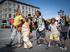 Tourists Chiara Fabricatore and Livio Cirillo walk their kids Agata, Luca and Lorenzo along Place Jacques Cartier in July 2022.