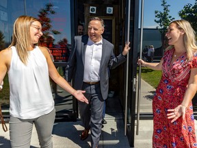 François Legault leaves a campaign lunch with Coalition Avenir Québec candidates Eve Bélec, left, and Marilyne Picard in Vaudreuil-Dorion Sept. 3, 2022.