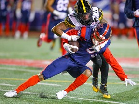 Montreal Alouettes receiver Tyson Philpot is tackled by Hamilton Tiger-Cats' Kameron Kelly after catching a pass during first half in Montreal on Sept. 23, 2022.