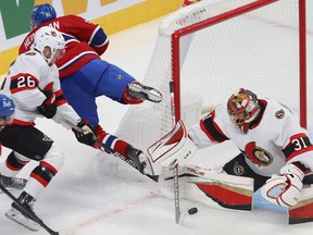 Emil Heineman (51) de los Montreal Canadiens pasa por encima del palo de Erik Brannstrom (26) de los Ottawa Senators durante el juego frente al portero Anton Forsberg durante el primer período de acción de la NHL de pretemporada en Montreal el martes 4 de octubre de 2022.