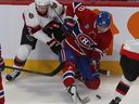 Montreal Canadiens' Juraj Slafkovsky (20) and Ottawa Senators' Artem Zub (2) trie to get control of the puck during first period pre-season NHL action in Montreal on Tuesday Oct. 4, 2022.