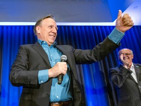 Premier François Legault waving with microphone in hand