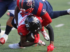 Montreal Alouettes' Adarius Pickett brings down Tyrie Adams during second half in Montreal on Oct. 10, 2022.