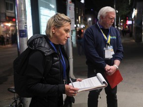 Julie Grenier of Mouvement pour mettre fin à l’itinérance à Montréal and Welcome Hall Mission CEO Sam Watts listen to a couple outside the Beaudry métro station Tuesday, October 11, 2022 for the census of the unhoused population.