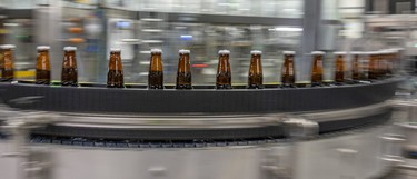 Bottles of beer roll along the production line at the Molson Coors brewery in Longueuil.