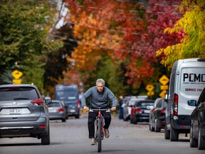 Changing leaves provide a backdrop for a cyclist on 55th ave. in the Lachine Oct. 7, 2022.