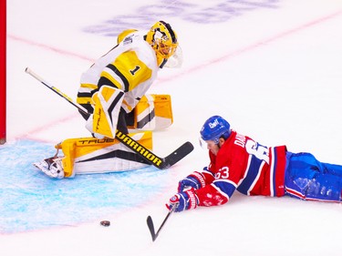 Canadiens' Evgenii Dadonov can't control of the puck after being checked in front of Pittsburgh Penguins Casey DeSmith during first period of National Hockey League game in Montreal Monday Oct. 17, 2022.