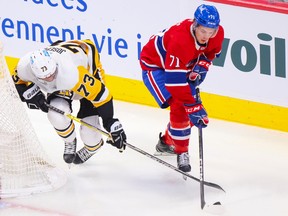Montreal Canadiens forward Jake Evans competes for a loose puck with the Pittsburgh Penguins' Pierre-Olivier Joseph during second period in Montreal on Oct. 17, 2022.