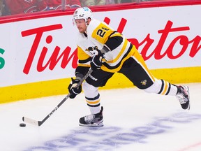 Penguins' Jeff Petry clears the puck in his own zone during his first game against the Montreal Canadiens, his former team, in first period of National Hockey League game in Montreal Monday Oct. 17, 2022.