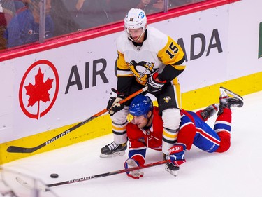 Canadiens' Chris Wideman reaches through Pittsburgh Penguins' Josh Archibald's legs to try to play the puck during the second period at the Bell Centre in Montreal Monday Oct. 17, 2022.
