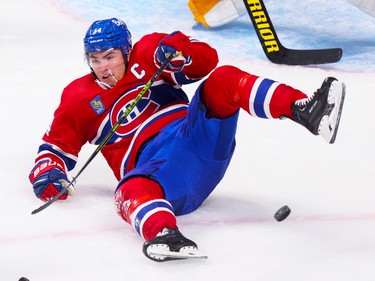 Canadiens' Nick Suzuki falls to the ice after being tripped by Pittsburgh Penguins' Jeff Petry during the second period at the Bell Centre in Montreal Monday Oct. 17, 2022.  Petry was penalized on the play.