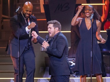 Michael Bublé bumps fists with a backup singer during his show at the Bell Centre in Montreal Tuesday Oct. 18, 2022.