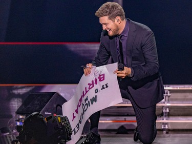 Michael Bublé autographs a fan's poster during his show at the Bell Centre in Montreal Tuesday Oct. 18, 2022.