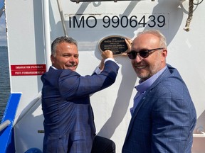 Jacques Tanguay, president and CEO of Ocean Group, left, and Stéphane Lafaut, president of the Société des traversiers du Québec, install a nameplate on the NM Rivière Saint-Augustin on Aug. 24, 2022.