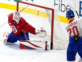 Montreal Canadiens winger Juraj Slafkovsky slips the puck past goaltender Sam Montembeault during a team practice in Brossard on Oct. 18, 2022.