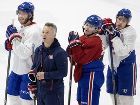 Montreal Canadiens head coach Martin St-Louis calls out drills as  Mike Hoffman, from left, Cole Caufield and Brendan Gallagher look on during a team practice in Brossard on Oct. 18, 2022.