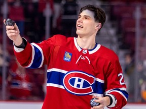 The Canadiens’ Juraj Slafkovsky gets ready to toss a puck into stands after scoring his first NHL goal and being named the game’s first star after a 6-2 victory over the Arizona Coyotes Thursday night at the Bell Centre.