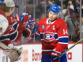 Canadiens' Nick Suzuki gets high fives from teammates on the bench after scoring a penalty shot goal during the second period of a National Hockey League game against the Arizona Coyotes in Montreal Thursday Oct. 20, 2022.