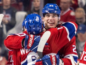 Juraj Slafkovsky of the Canadiens gets a hug from teammate Chris Wideman following the team's win over the Arizona Coyotes in a National Hockey League game in Montreal on Thursday, Oct. 20, 2022.