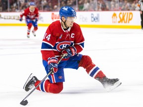 Canadiens' Nick Suzuki looks to make a play from one knee during the third period of a National Hockey League game against the Arizona Coyotes in Montreal Thursday Oct. 20, 2022.