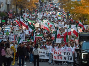 People march through the streets of Montreal to show solidarity with Iranian women on Saturday, Oct. 22, 2022.