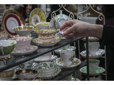 A man looks at a label on a china cup at a vintage bazaar at Saint-Jean-Berchmans Church in Montreal on Sunday, Oct. 23, 2022.