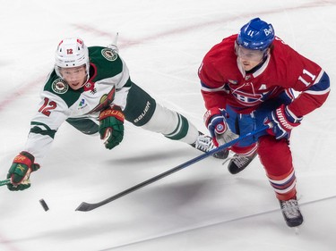Minnesota Wild left wing Matt Boldy (12) reaches for the puck against Montreal Canadiens right wing Brendan Gallagher (11) during 1st period NHL action at the Bell Centre in Montreal on Tuesday Oct. 25, 2022.