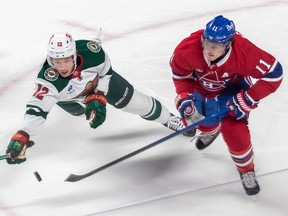 Minnesota Wild left wing Matt Boldy (12) reaches for the puck against Montreal Canadiens right wing Brendan Gallagher (11) during 1st period NHL action at the Bell Centre in Montreal on Tuesday October 25, 2022.