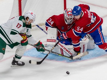 Montreal Canadiens defenceman Jordan Harris (54) prevents Minnesota Wild left wing Marcus Foligno (17) from getting his stick on the puck in front of Montreal Canadiens goaltender Jake Allen (34) during 2nd period NHL action at the Bell Centre in Montreal on Tuesday Oct. 25, 2022.