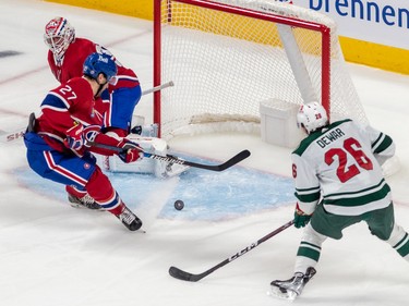 Montreal Canadiens goaltender Jake Allen (34) watches as Montreal Canadiens left wing Jonathan Drouin (27) clears the puck before Minnesota Wild center Connor Dewar (26) could get to it during 1st period NHL action at the Bell Centre in Montreal on Tuesday Oct. 25, 2022.