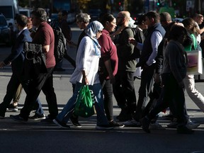 People walk along Ste-Catherine St. on Tuesday October 25, 2022.