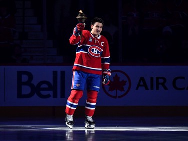 Canadiens' captain, Nick Suzuki #14, skates onto the ice with the flame during the home opening pregame ceremony prior to the game against the Toronto Maple Leafs at Centre Bell on October 12, 2022 in Montreal.