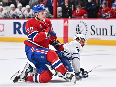 Juraj Slafkovsky #20 of the Montreal Canadiens, in his first career NHL game, takes down Auston Matthews #34 of the Toronto Maple Leafs during the third period at the Bell Centre on Oct. 12, 2022 in Montreal.