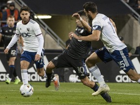 CF Montréal's Joaquin Torres squeezes between D.C. United's Martin Rodriguez and Steve Birnbaum with the ball during second half MLS action in Montreal on Saturday, Oct. 1, 2022.