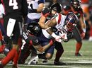 Alouettes running back William Stanback (31) is tackled by Ottawa Redblacks linebacker Adam Auclair (32) and defensive back Damon Webb (34) during second half CFL football action in Ottawa on Friday, Oct. 14, 2022.  