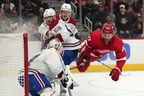 Detroit Red Wings centre Michael Rasmussen (27) is tripped up by Canadiens defenceman David Savard (58) in front of the net as goaltender Jake Allen defends on Friday, Oct. 14, 2022, in Detroit.  