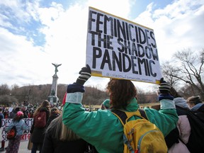 A person holds a placard during a protest in Montreal April 2, 2021.