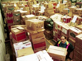 Boxes of confiscated cigarettes are piled up in an RCMP warehouse in Montreal in this photo dated Oct. 13, 1992. The name of the man in the photo, presumably an RCMP employee, is not available.