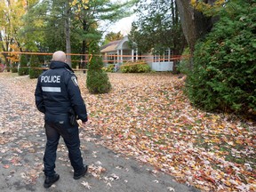 Police survey the scene where two people were found dead, Thursday, Oct. 20, 2022  in Île-Bizard.
