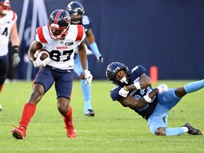 Montreal Alouettes receiver Eugene Lewis escapes a tackle attempt by Toronto Argonauts defensive-back Robert Priester during first half in Toronto on June 16, 2022.